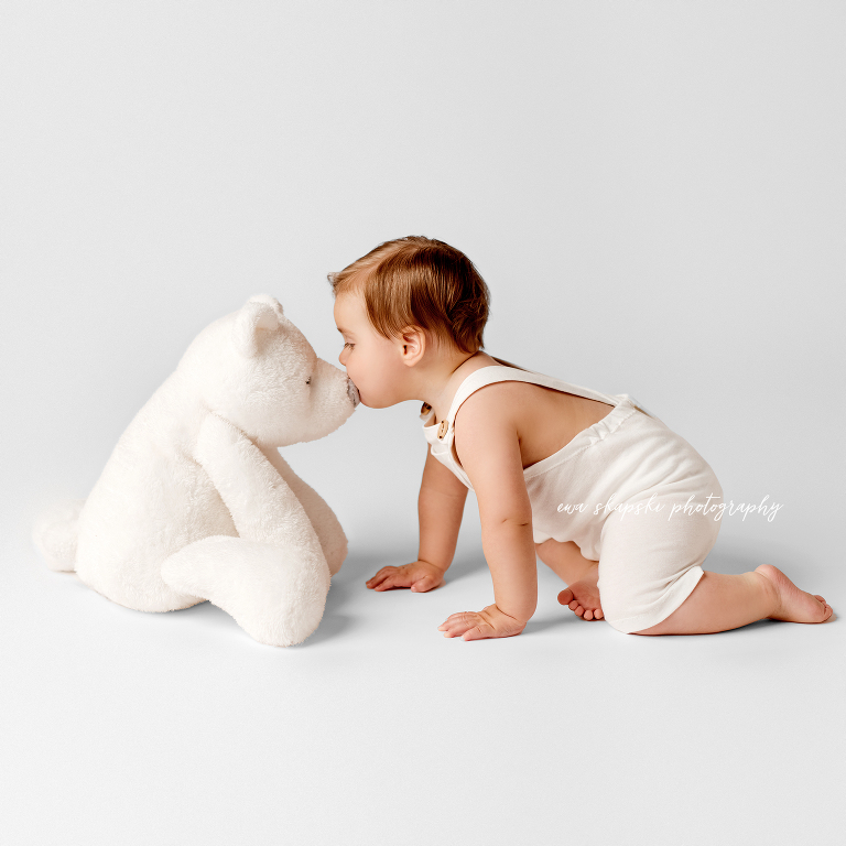 baby kissing teddy bear